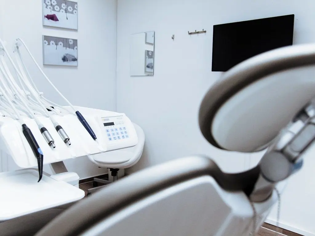 A bright, modern clinic treatment room with dental and imaging equipment.